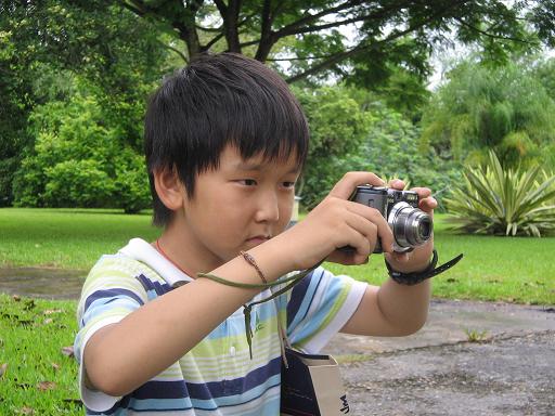 A kid concentrating on photographing plants